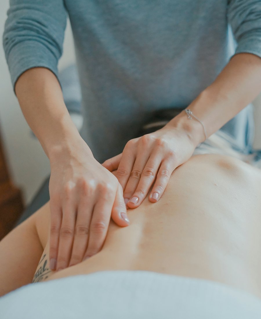 Mains d’une praticienne pendant un massage du dos